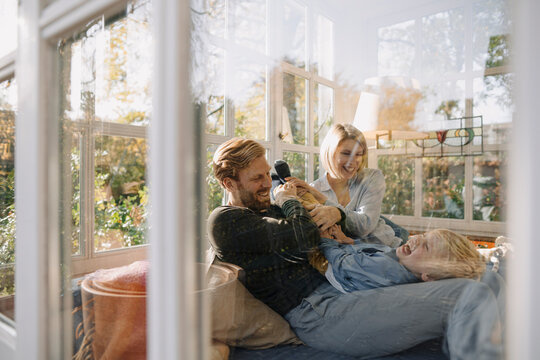 Happy family having fun in sunroom at home