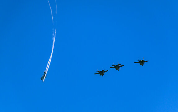 Stealth fighter jets fly in formation in a clear blue sky