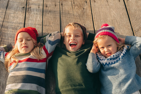 A boy and girl enjoy family bonding on a wooden deck