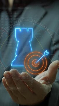 Open hand vertical shot holding glowing chess rook castle next to target bullseye sign icon. Cyberpunk neon light theme, targeted corporate strategy and strategic objective milestone concept.