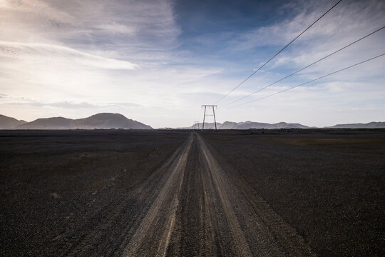 Gravel road cuts through dark volcanic highlands in Iceland