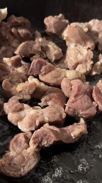 Frying meat pieces with steam in pan for laghman and Central Asian noodle dishes



