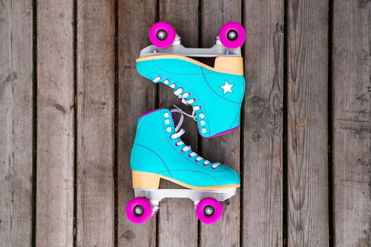 Multi colored roller skates on floorboard