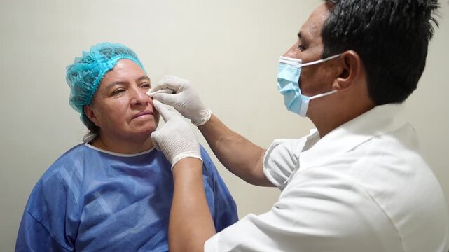 Doctor examining a female patient's face after wart removal during dermatological follow up