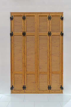 Closed Brown Wood Louvered Door Shutters at House