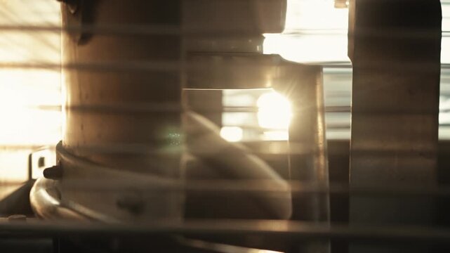 Close-up shot of rotation of spiral tool in industrial-grade spiral mixer during dough kneading process in kitchen. Bread-making stage in private bakery. Warm lighting