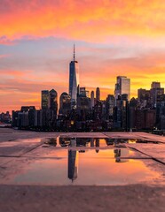 Fototapeta premium Vibrant City Skyline Glowing at Sunset with Reflection on Wet Waterfront Promenade