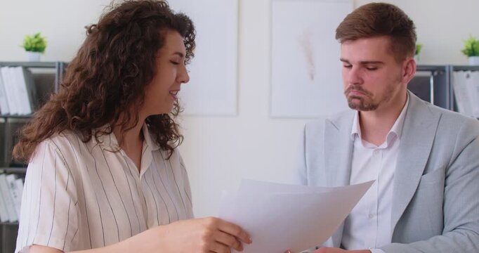 Business meeting for documents analysis and paperwork discussion in office. Woman explaining data report and solutions to colleague, busy professional employees discuss agreement, project together