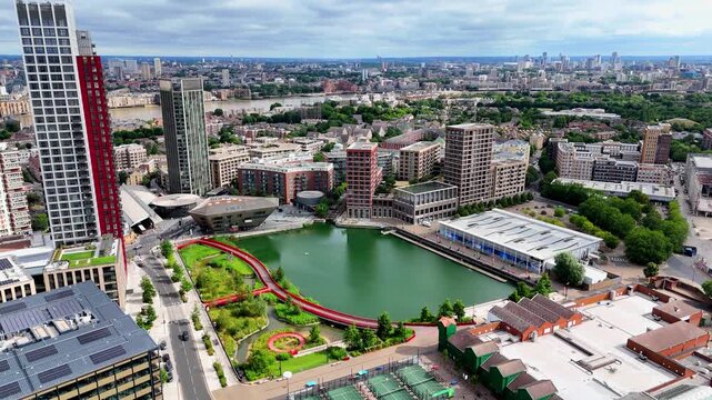 Aerial descent into Canada Water in London, showcasing modern urban development, new residential buildings, waterways and regeneration around this evolving Docklands district.