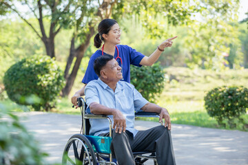 Obraz premium Smiling female nurse caregiver and senior man in wheelchair with sunny park. Positive image depicting dedicated professional care.
