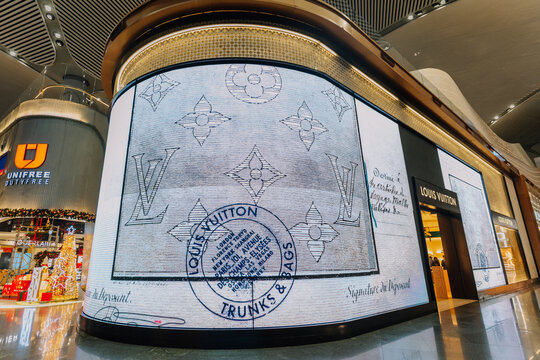 Louis Vuitton storefront display featuring iconic monogram pattern and branding in a modern shopping mall environment