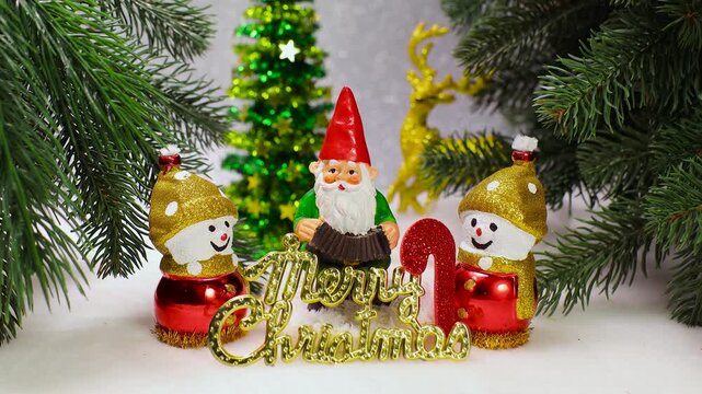 On a white background among the Christmas trees there is a gnome with two snowmen and letters