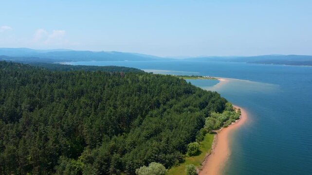 Shiroka polyana reservoir scenic drone panoramic view green pine forest shoreline clear blue water hills background summer sunny day travel destination concept Bulgaria.