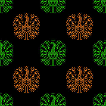Seamless pattern with peacock motifs in cross-stitch embroidery style. Green and orange bird silhouettes on black background. Traditional folk art inspired design, perfect for textile prints.
