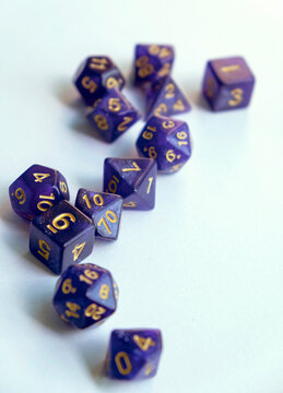 Purple RPG polyhedral dice set scattered on a white background