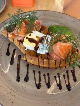 Delicious salmon dish with poached egg and fresh herbs on a plate  