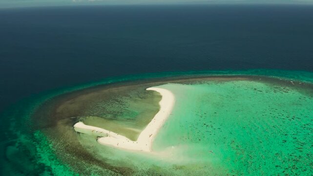 Beautiful beach on tropical island surrounded by coral reef, sandy bar with tourists, top view. Sandbar Atoll. Summer and travel vacation concept, Camiguin, Philippines.