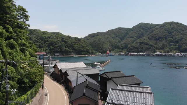 Drone shot rising and capturing the scenic panorama of Ine Bay and traditional Funaya boat houses in Kyoto, Japan