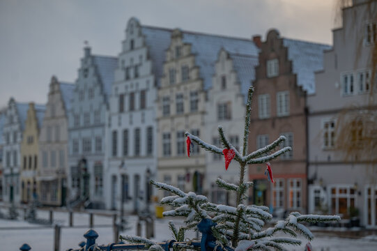 Winter Christmas atmosphere with decorated Christmas tree and traditional historic gabled houses in Friedrichstadt Germany.