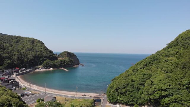 Aerial drone view tracking forward over the scenic Tomari Beach and the peaceful bay in Ine, Kyoto, Japan