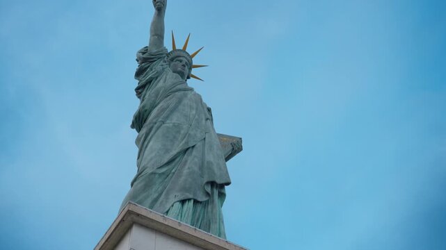 Statue of Liberty replica monument stands against the sky in Paris France. French landmark copper sculpture represents freedom and independence for international travel and tourism industry.