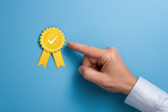 Quality assurance concept hand pointing to yellow ribbon award with checkmark symbol