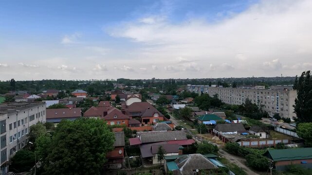 Panoramic aerial view of residential area with houses and apartment buildings under cloudy sky