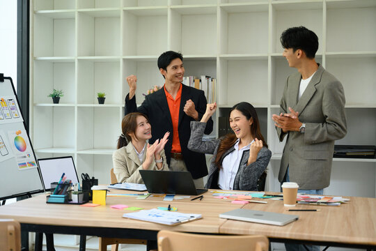 Excited Asian Business Team Celebrating Success in Creative UX UI Design Meeting at Modern Office