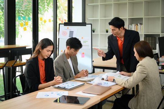 Angry Boss Confronting Team During Business Meeting Over Failure and Disrupted Plan in Modern Office