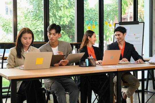 Executive HR Consultants Preparing New Employee Interviews in Modern Conference Room with Laptops and Whiteboard
