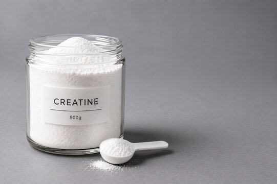 Glass jar with creatine powder and a measuring scoop