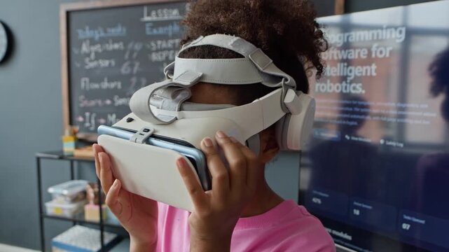 African American child wearing virtual reality headset during robotics lesson in classroom. Footage is ideal for promoting STEM education, modern school curricula, and interactive learning tools