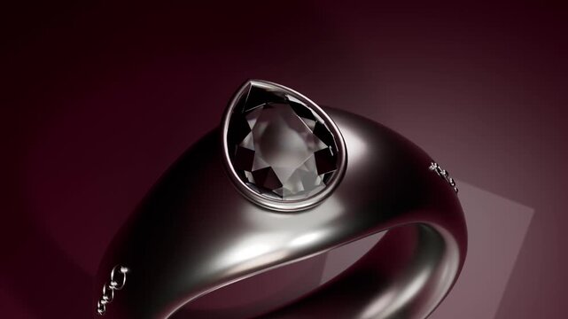 Turntable starting, rotating dark metal ring in studio, showing pear-shaped gemstone and studs