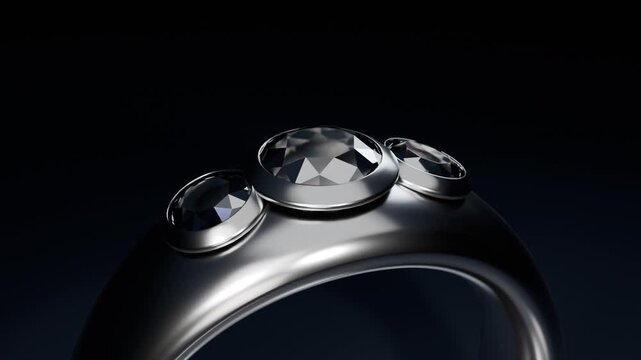 Rotating polished ring after camera movement, revealing three bezel-set stones in studio