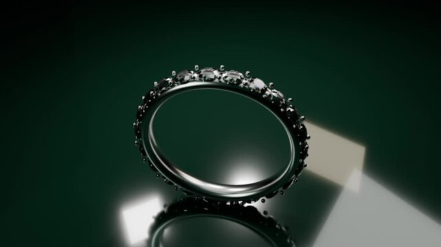 Rotating gemstone ring rolling from tilt on glossy dark green platform, showing softbox lights