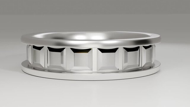 Lifting camera, rotating silver ring on base in studio revealing triangular tab and inner rim