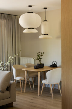 Modern Minimalist Dining Area with Elegant Hanging Lamps and Natural Light