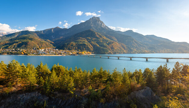 Serre-Poncon Lake with Savines-le-Lac village, its bridge, and Grand Morgon mountain in autumn. Hautes-Alpes, French Alps, France