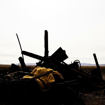 Silhouetted Debris Against a Stark, Overcast Horizon