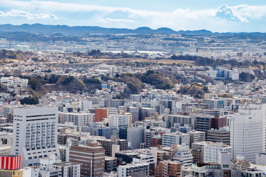 青空の下に広がる横浜市街地のビル群と高層マンションの俯瞰