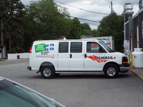 Gatineau,Quebec, Canada &ndash; May 24, 2026: A white "U-Haul van" parked in a lot features advertisements promoting "meilleur rapport qualit&eacute;-prix" for their "camionpartage 24/7" rental service on Chem. d'