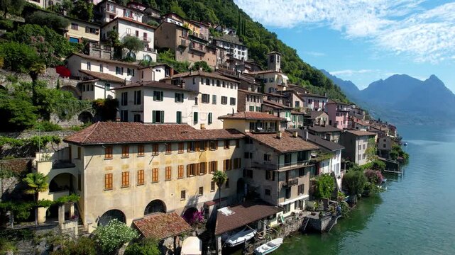 Cinematic Vertical Drone Reveal of Cascading Houses in Gandria Village Lake Lugano Switzerland Iconic Lakeside Architecture Vibrant Colorful Buildings Against Alpine Mountains Authentic Slow Living 4K