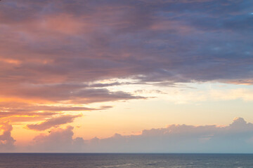 Obraz premium Colorful sunset over the sea with dramatic orange after rain clouds.