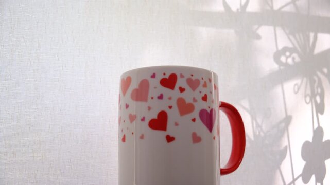 Cup of tea or coffee in the morning light, the warm beverage inviting a moment of pause. Mood is serene, contemplative, simple pleasure of a quiet morning. Light and shadow. Home decor inspiration