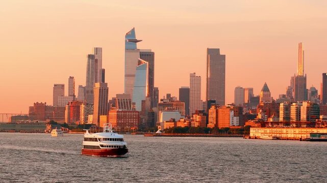 Ferry passing under Manhattan Bridge on East River. White catamaran creates wake beneath blue steel span with Brooklyn Bridge visible behind.