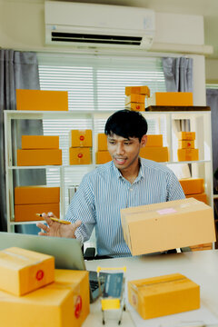 Friendly male entrepreneur talking to microphone during e-commerce live broadcast surrounded by parcel boxes.
