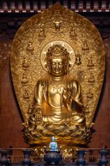 Fototapeta premium Grand Golden Statue of Avalokitesvara Bodhisattva Seated on a Lotus Throne Inside Da Ci'en Temple in Xi'an, China