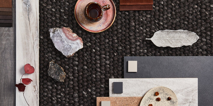 Stylish flat lay composition of architect moodboard with samples of building, brown textile and natural materials and personal accessories. Top view, template.