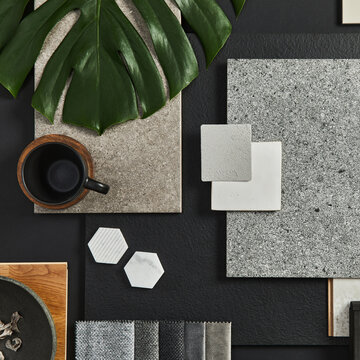 Modern Interior Design Flat Lay: Monstera Leaf, Textured Tiles, Fabric Swatches, and Ceramic Mug on Black Background