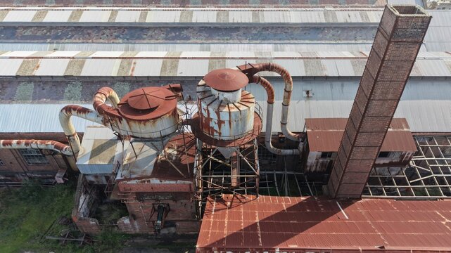 Industrial decay highlighting abandoned factory with rusty silos and chimney